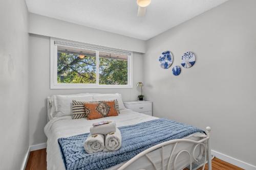 a bedroom with a bed and a window at Waterfront Oasis with Pool, Hot Tub & Pet Friendly in Kelowna