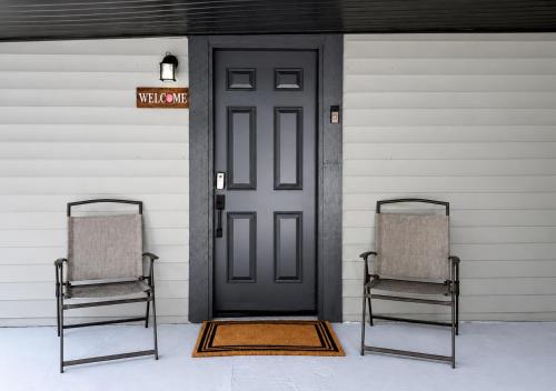 two chairs sitting in front of a black door at Small Space Charm in Tampa