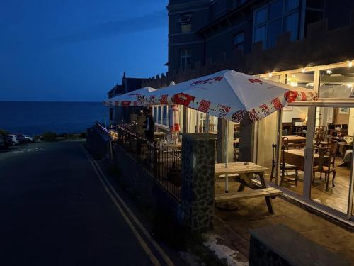 a table and an umbrella on a balcony at The Marine Hotel in Criccieth