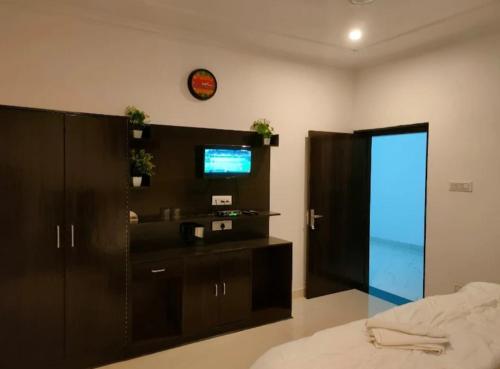 a bedroom with a bed and a tv on a wall at Hostel Arabbian nights in Khajurāho