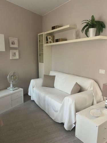 a white bedroom with a bed and a couch at Appartamenti al Rizzo dei Santi in Lovere