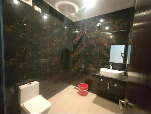 a bathroom with a toilet and a sink and a mirror at Hostel Arabbian nights in Khajurāho