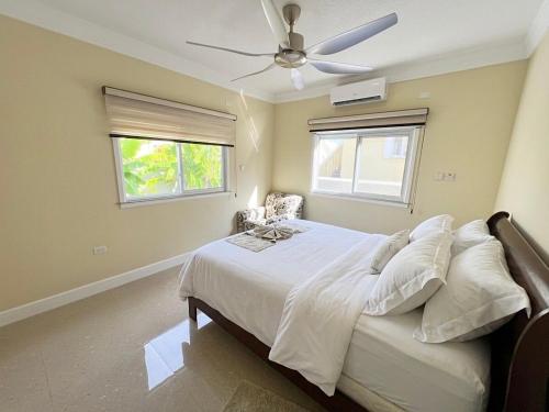 a bedroom with a bed with a ceiling fan at Gold Sun Villa in Saint Annʼs Bay