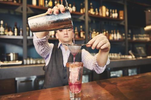 a man is making a cocktail in a bar at Hotel Vandivort in Springfield