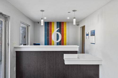 a lobby with a reception desk and a colorful wall at Motel 6 - McComb, MS in McComb