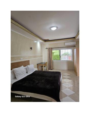 a bedroom with a bed and a table at Le MoniPol Hôtel in Franceville