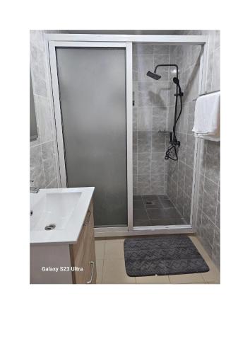 a shower with a glass door in a bathroom at Le MoniPol Hôtel in Franceville