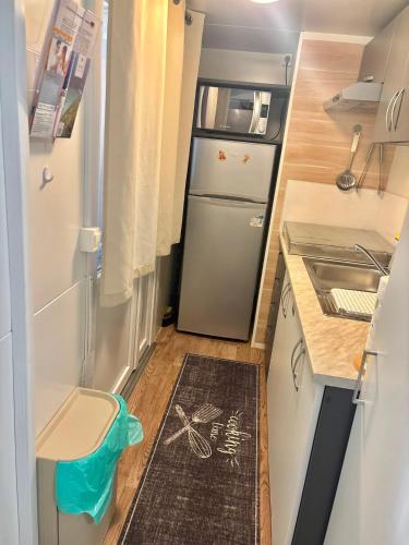 a small kitchen with a refrigerator and a sink at Mobile Home David-Camp Soline in Biograd na Moru
