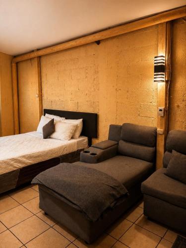 a bedroom with a bed and a couch and a chair at Arianas Place 2 in Huehuetenango