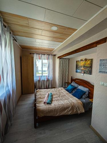 a bedroom with a large bed with blue pillows at Appartement charmant et atypique, wifi, terrasse, jardin in Schleithal