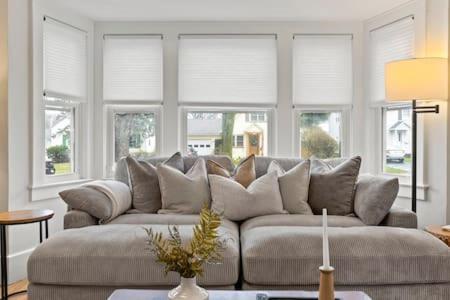 a couch in a living room with windows at Rochester Gem: 3BR Near All! in Rochester