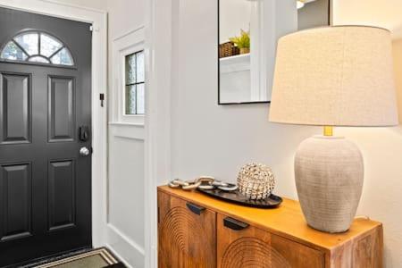 a lamp on top of a wooden table next to a door at Rochester Gem: 3BR Near All! in Rochester