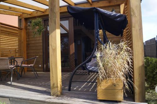 a porch with a swing and a table and chairs at Leniwe Chaty in Szklarnia