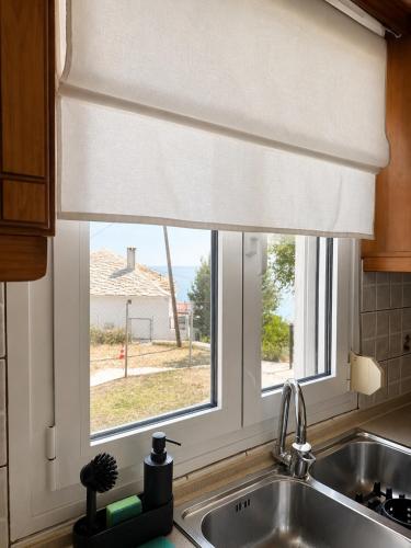 a kitchen sink with a window with a window shade at THEONprivehouse in Koinyra