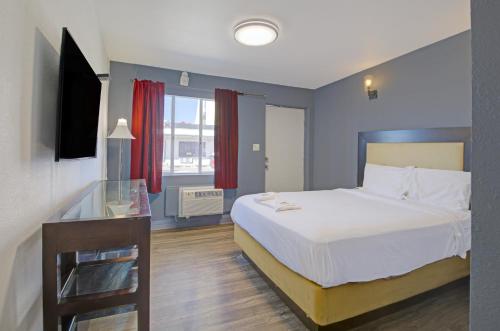 a hotel room with a bed and a television at OYO Oasis Motel Las Vegas I-15 in Las Vegas