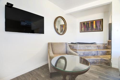 a living room with a glass table and a chair at OYO Oasis Motel Las Vegas I-15 in Las Vegas