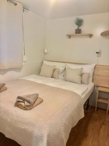 a large white bed with a towel on it at Mobile Home David-Camp Soline in Biograd na Moru