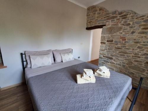 a bedroom with a bed and a stone wall at Bella vista 2 in Castellino Tanaro