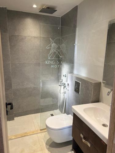 a bathroom with a shower and a toilet and a sink at King's Gate Royal View INN in Cairo