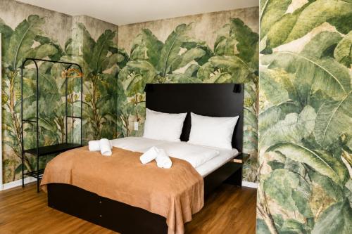 a bedroom with a bed and a mural of plants at Les Jardins Blankenese in Hamburg