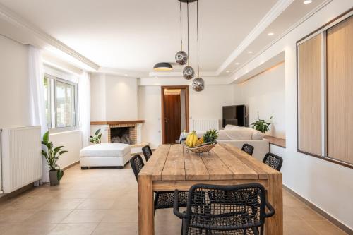 a living room with a wooden table and chairs at CASA di FLORI in Epáno Flória