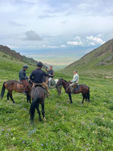 a group of people riding horses in a field at Horse Riding Son-kol in Song-Kul