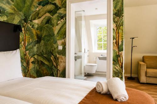 a bedroom with a bed and a bathroom at Les Jardins Blankenese in Hamburg