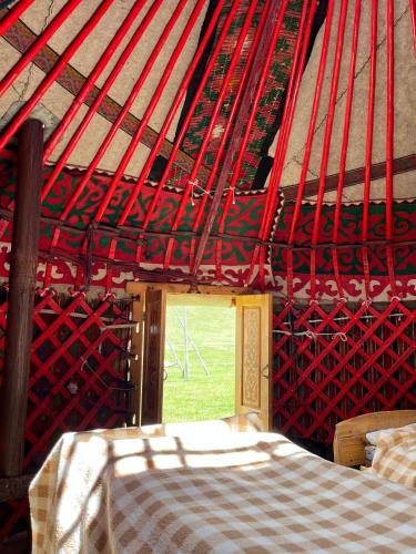 a room with a bed and a red wall at Horse Riding Son-kol in Song-Kul