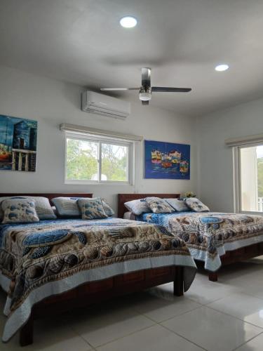 a bedroom with two beds and a ceiling fan at Casa Venus in El Gigante