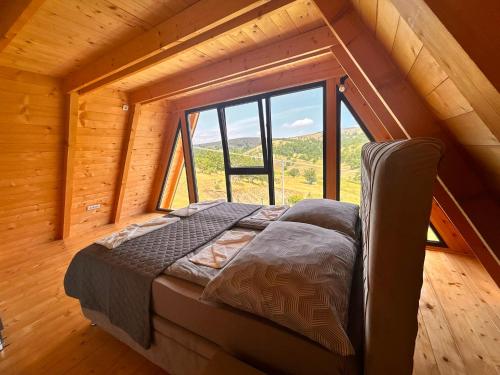a bed in a room with a large window at Stress Away in Zlatibor