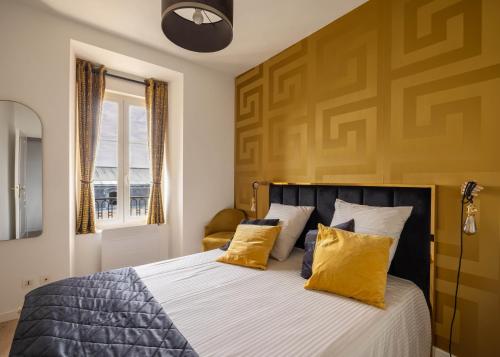 a bedroom with a large bed with yellow pillows at La Bulle Dorée in Épernay