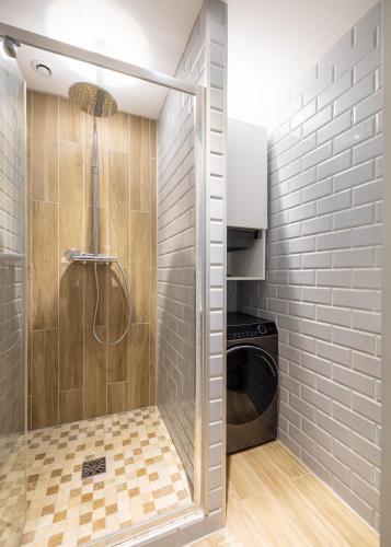 a shower in a bathroom with a washing machine at La Bulle Dorée in Épernay