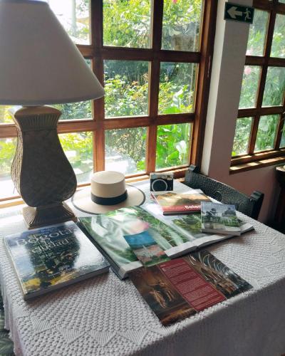 a table with a lamp and magazines on it at Alojamiento Rural San Antonio in Ubaté