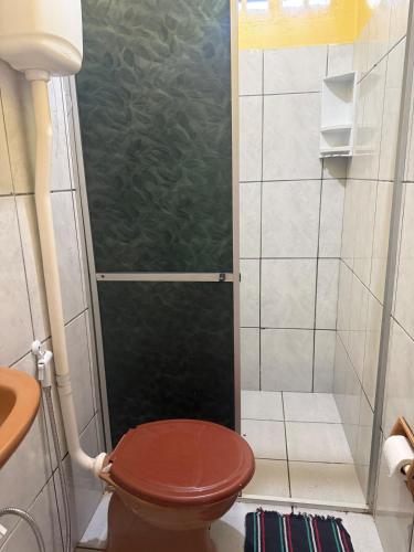 a shower with a wooden toilet in a bathroom at Casa Fronteira in Oiapoque