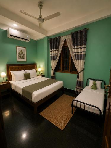 a green bedroom with two beds and a window at Cleopatra Rest House in Nilaveli