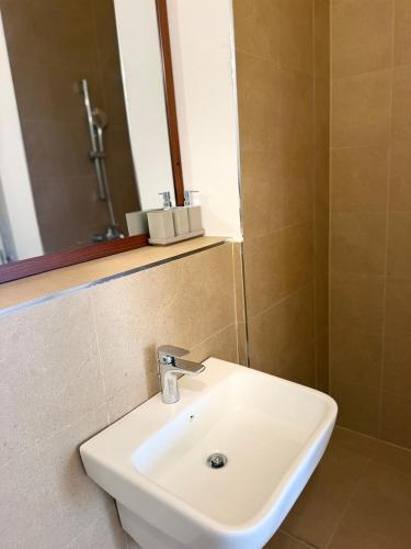 a bathroom with a white sink and a mirror at Two Bedroom Moyoni Apartment in Mchamba Wima