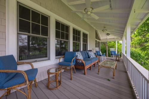 a porch with blue chairs and tables and windows at Tidebend in Gloucester
