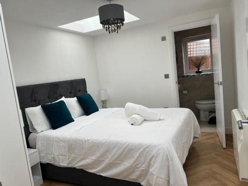 a bedroom with a large white bed with blue pillows at Modern peaceful property Breakfast included in Blean