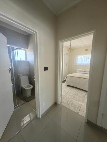 a bedroom with a bed and a bathroom with a mirror at 55 On Paisley in Bulawayo