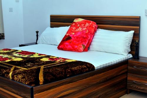 a bed with a red pillow on top of it at Hilltop Apartments in Mosan
