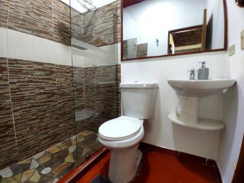 a bathroom with a toilet and a sink and a shower at Alojamiento temático Rancho Texas in La Mesa
