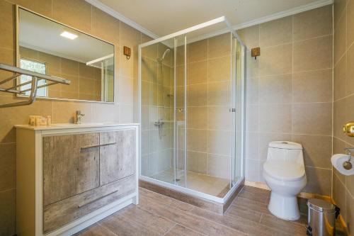 a bathroom with a toilet and a glass shower at Spa Pirque & Hotel in Pirque