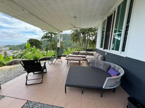 a porch with chairs and a couch and a table at Villa Olympus Sea View Private Pool 4BR Near Kata Beach in Kata Beach