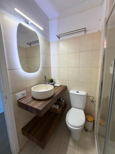 a bathroom with a sink and a toilet and a mirror at LĀ KAI - Piso Carabelas in Candelaria