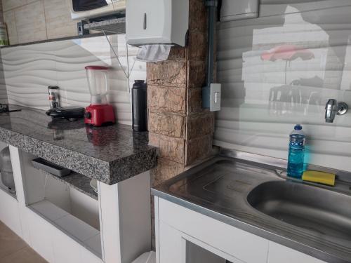 a kitchen with a sink and a counter top at Recanto dos Loureiros in Saquarema