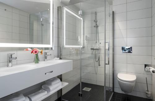 a bathroom with a sink and a toilet and a shower at Thon Hotel Terminus in Oslo