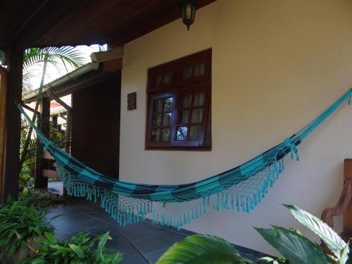 a hammock on the side of a house at Pousada da Mantiqueira in Visconde De Maua