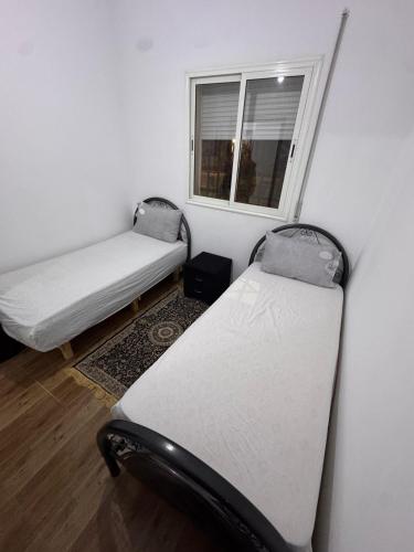 two beds in a room with a window at Maison céder in Azrou
