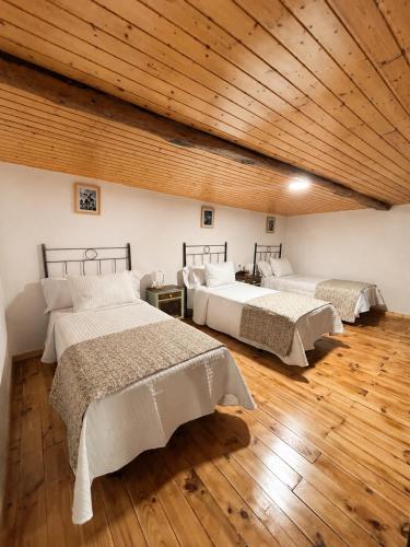 two beds in a room with a wooden ceiling at Casa Portos in Lestedo