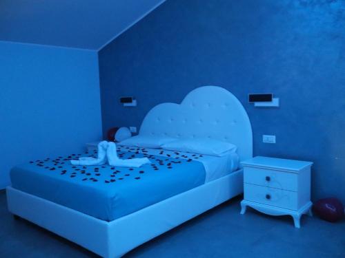 a blue bedroom with a bed and a night stand at Esmeralda B&B in Casa San Biagio